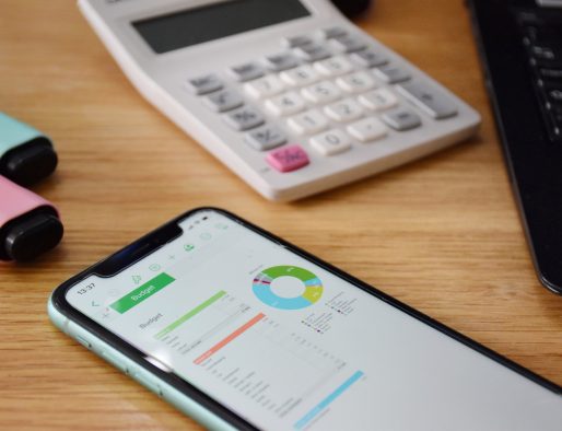 Budgeting on a smart phone with a calculator and pens