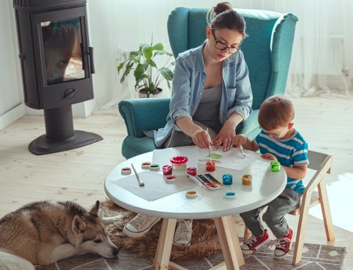Mom and child paint together at home with dog