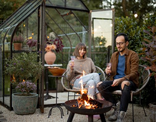 Young couple have a dinner by the fire at backyard